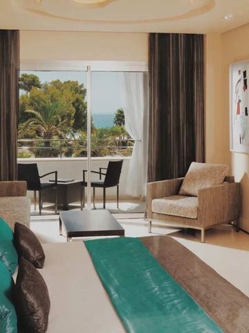 Hotelzimmer mit gemütlicher Sitzecke und Balkon mit Meerblick