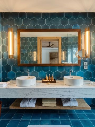 Luxuriöses Badezimmer mit blauen Fliesen und Doppelwaschbecken.