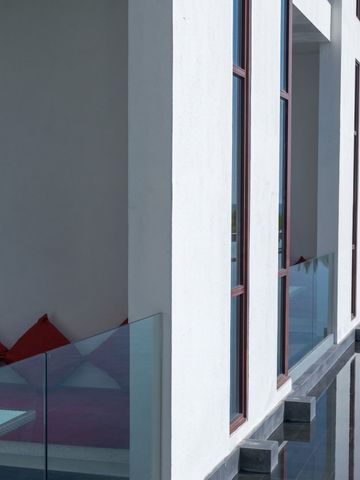 Minimalistisches Design mit weißen Wänden und roten Kissen in einem modernen Hotel