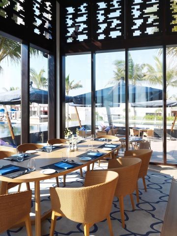 Elegantes Restaurant mit Blick auf Pool und Palmen