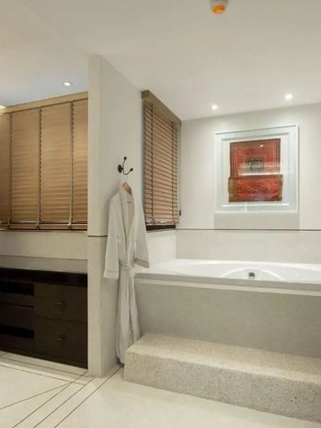 Modernes Badezimmer mit großer Badewanne und Kunst an den Wänden