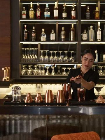 Moderne Hotelbar mit vielseitigem Getränkeangebot und Barkeeper