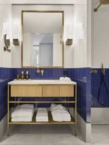 Luxuriöses Badezimmer mit blauen Fliesen und Holzelementen