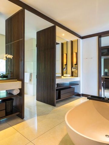 Elegantes Badezimmer mit moderner Badewanne und großen Spiegeln.