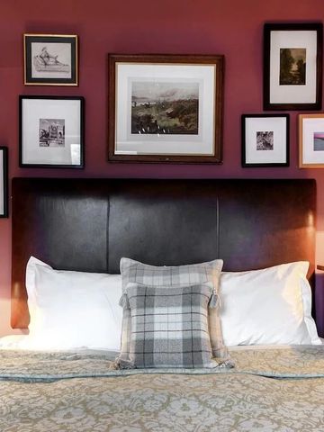 Gemütliches Schlafzimmer mit Kunstwerken an der Wand und luxuriösem Bett