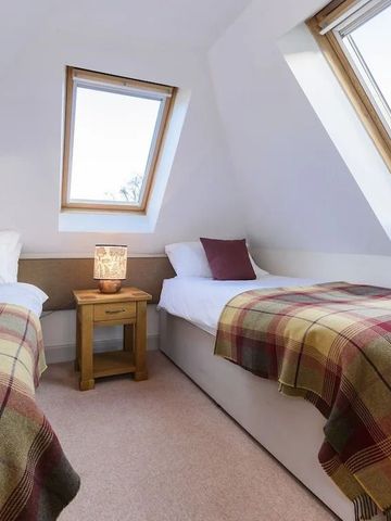 Gemütliches Doppelzimmer mit Dachfenstern und karierten Decken