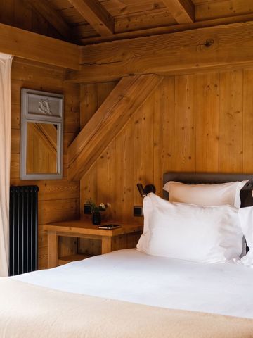 Gemütliches Schlafzimmer mit Holzwänden und einladendem Bett