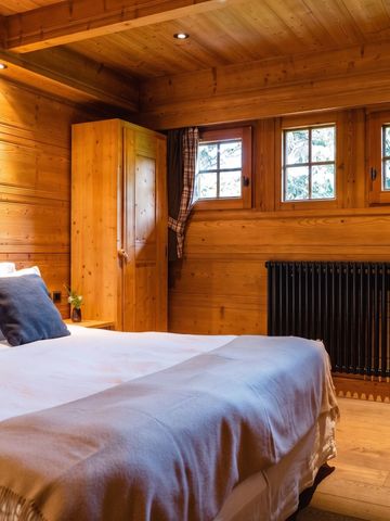 Geräumiges, holzverkleidetes Schlafzimmer mit Doppelbett und eleganter Einrichtung