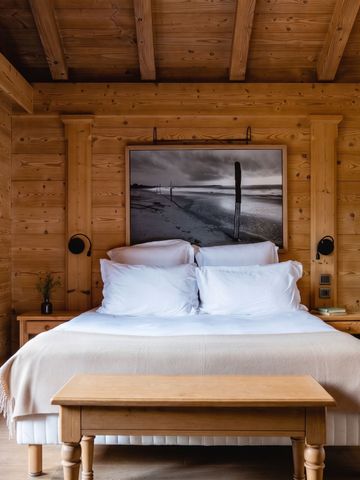 Schlafzimmer mit Holzmöbeln und großem Kunstwerk an der Wand