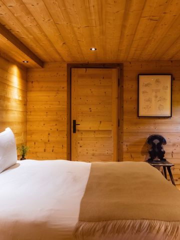 Holzgetäfeltes Schlafzimmer mit heller Beleuchtung und minimalistischer Dekoration