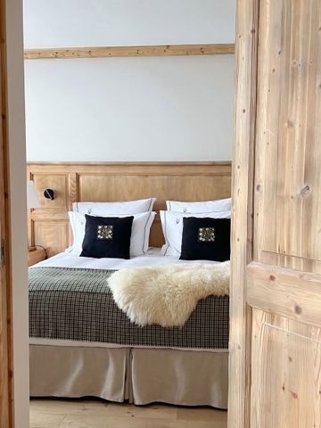 Einladendes Schlafzimmer mit natürlichem Holzdesign und luxuriösen Textilien.