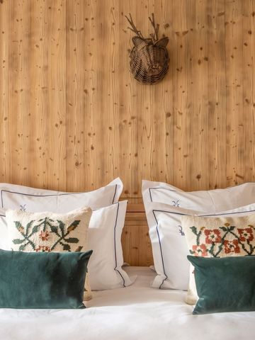 Gemütliches Schlafzimmer mit Holzwand und dekorativen Kissen