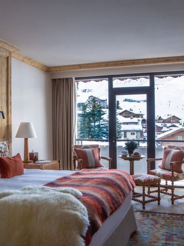 Elegantes Hotelzimmer mit Bergblick und rustikalen Holzmöbeln