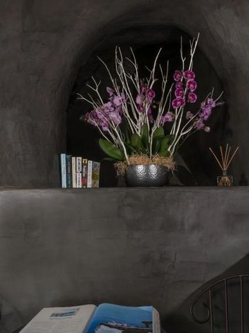 Dekoratives Arrangement aus Orchideen und Büchern in einer gemütlichen Nische.
