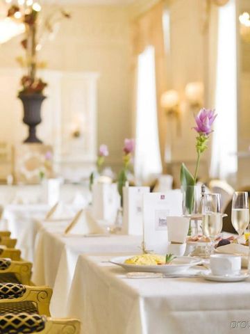 Elegantes Restaurant mit fein gedeckten Tischen und Blumenarrangements