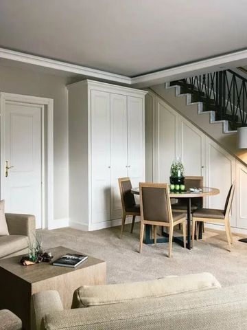 Elegantes Hotelzimmer mit gemütlicher Sitzecke und Esstisch.