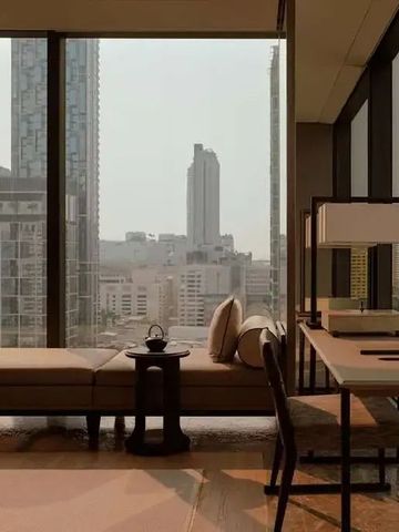 Zimmerblick mit Panoramafenstern und Sitzbereich mit Blick auf die Skyline von Bangkok
