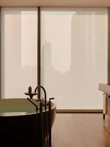 Freistehende Badewanne in einem eleganten Badezimmer mit großen Fenstern