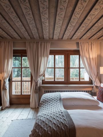Gemütliches Schlafzimmer mit traditionellen Holzbalkendecken und warmer Beleuchtung