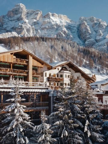 Alpenhotel aus Holz mit schneebedeckten Bergen im Hintergrund