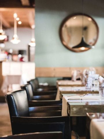 Gemütliches Restaurantambiente mit modernen Lampen und runden Spiegeln
