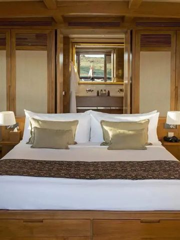 Luxuriöses Holzzimmer mit großem Bett und Kissen