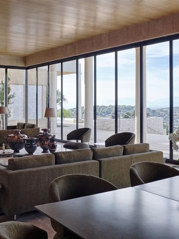 Hhelle Lounge mit großen Glasfenstern und Blick auf die Landschaft