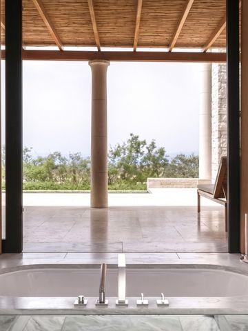 Badezimmer mit freistehender Badewanne und Blick auf Terrasse
