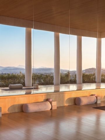 Yoga-Raum mit Holzsäulen und Blick auf die Landschaft bei Sonnenuntergang