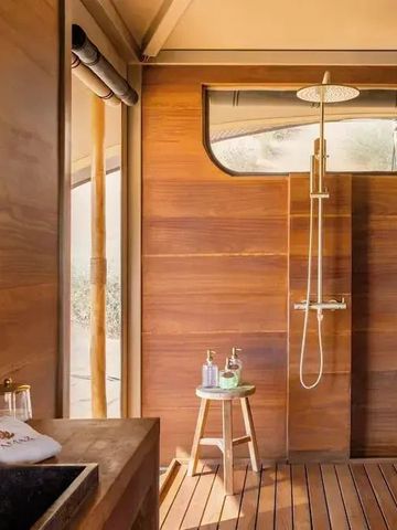 Luxuriöses Badezimmer mit Holzwänden und Regendusche im AMAR LUXURY DESERT ECOLODGE