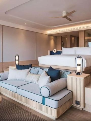 Modernes Schlafzimmer mit gemütlicher Sitzecke und stilvoller Beleuchtung