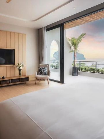 Zimmer mit großem Bett und Balkon mit Blick auf einen malerischen Sonnenuntergang