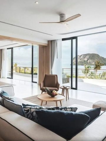 Wohnzimmer mit Meerblick durch große Fensterfront.