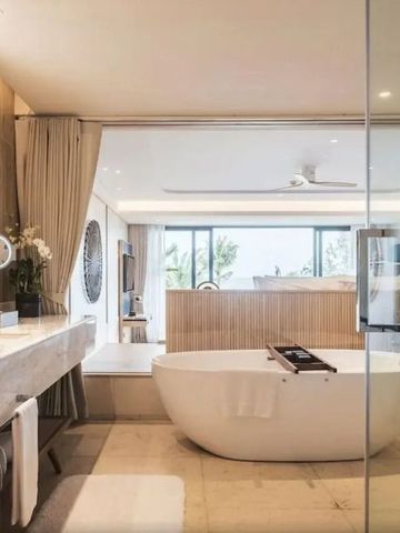 Luxuriöses Badezimmer mit freistehender Badewanne und großem Spiegel.
