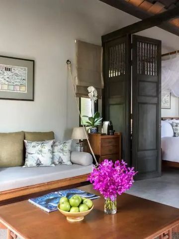 Gemütlicher Loungebereich mit violetter Blumendekoration im Hotelzimmer