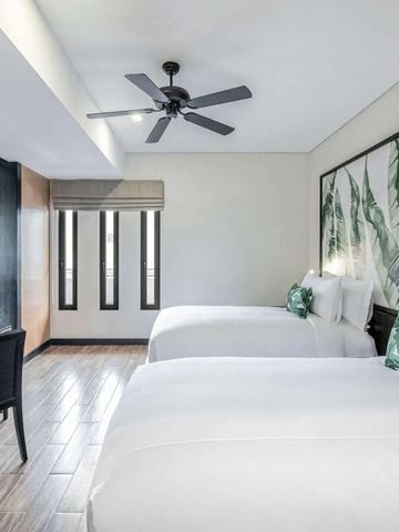 Zweibettzimmer mit modernem Dekor und Pflanzenmotiv an der Wand