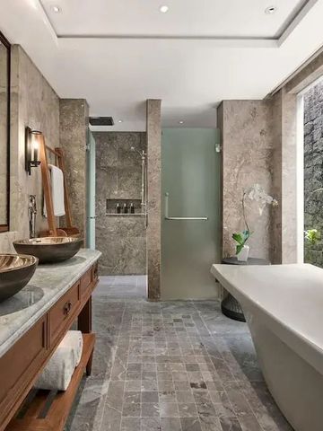 Elegantes Badezimmer mit freistehender Badewanne und Natursteinwänden