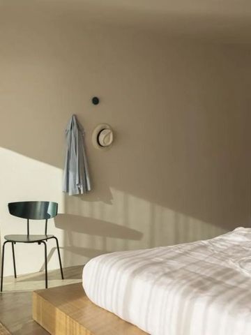 Helles Schlafzimmer mit großem Spiegel und elegantem Bett
