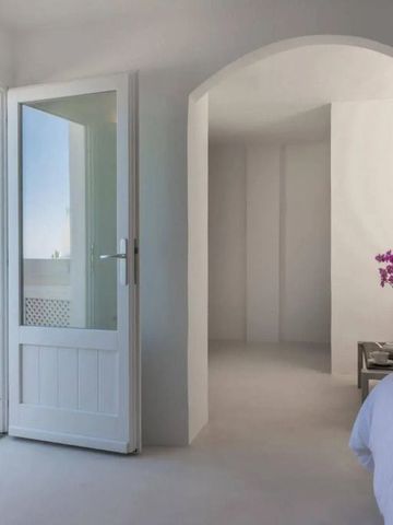 Helles Zimmer mit Blick auf das Meer durch eine offene Tür
