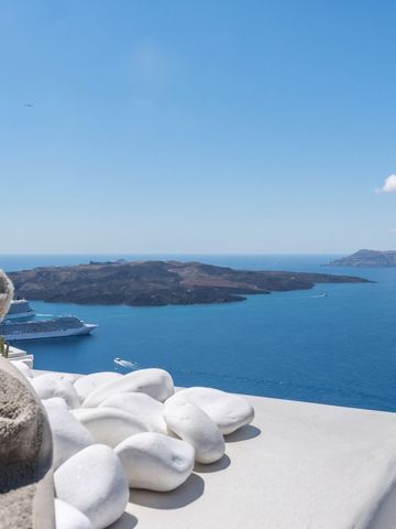 Blick auf das Meer und umliegende Inseln mit weißen Steinen im Vordergrund