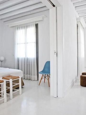 Geräumiges weißes Zimmer mit schlichtem, modernem Design.
