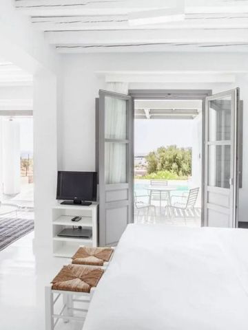 Helles Schlafzimmer mit Zugang zur Terrasse und Außenblick auf Pool.
