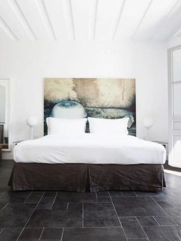 Geräumiges Schlafzimmer mit großem Bett und moderner Kunst.