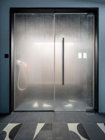 Luxuriöse Glasduschkabine mit sanfter Beleuchtung und modernem Design.