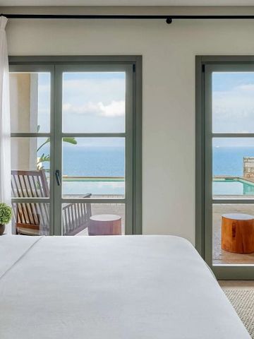 Hotelzimmer mit Zugang zu einem Balkon und Meerblick.
