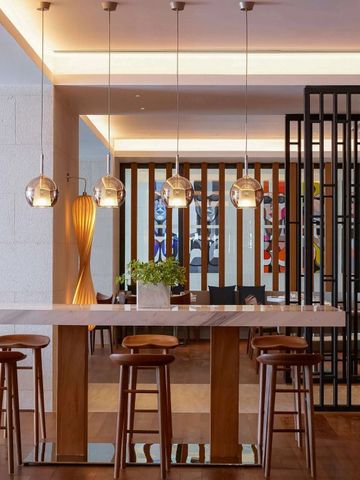 Moderne Bar mit stilvollen Hockern und Pendelleuchten