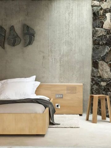 Minimalistisches Schlafzimmer mit Beton- und Natursteinwand im modernen Stil.