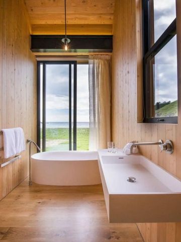 Luxuriöses Bad mit freistehender Badewanne und Blick auf die Natur