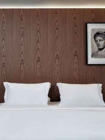 Detailaufnahme eines Hotelbetts mit Kunstwerken an der Wand