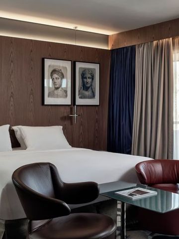 Geräumiges Hotelzimmer mit modernem Mobiliar und Kunstwerken
